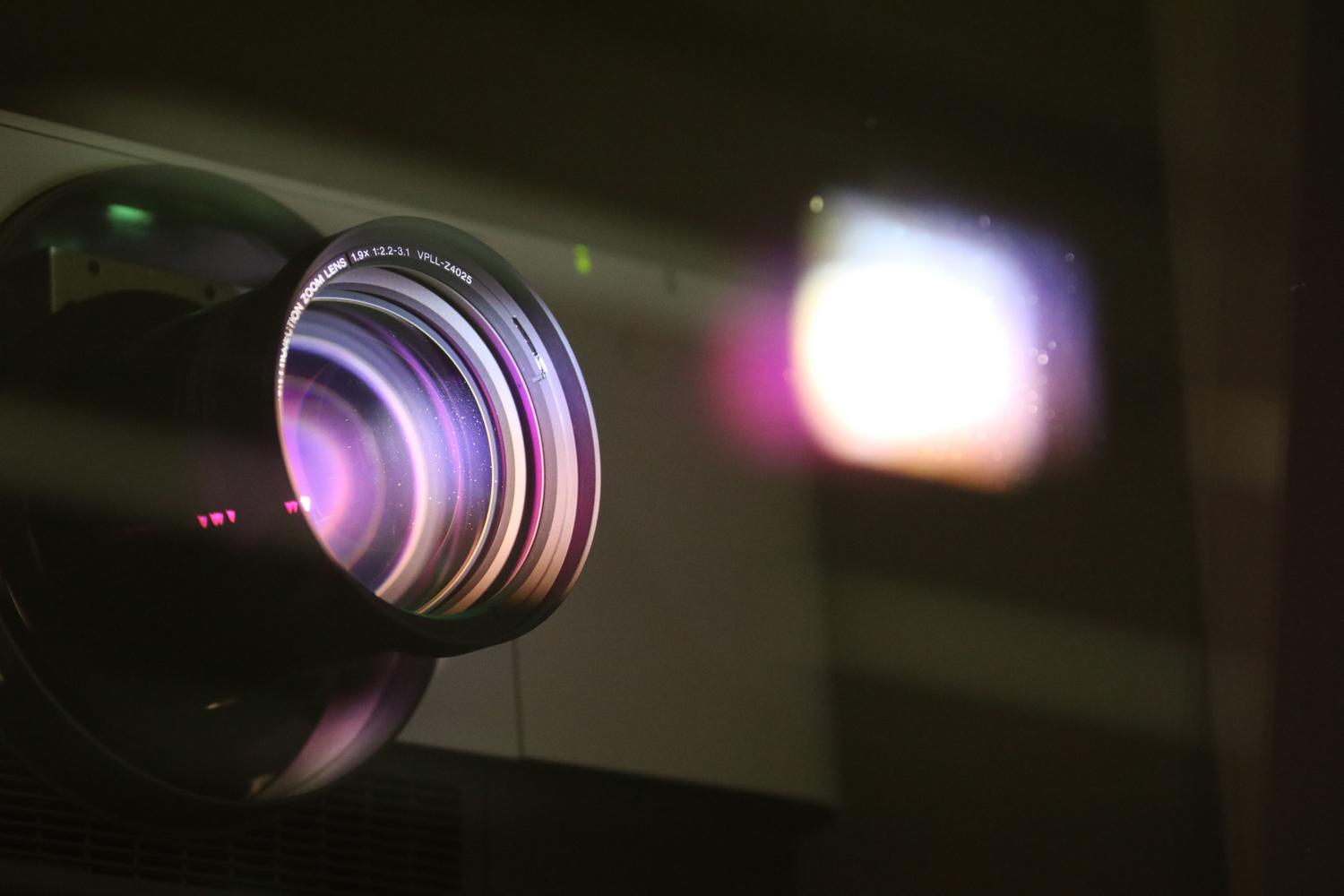 Primer plano detallado de la lente de un proyector profesional, resaltando la óptica y tecnología.