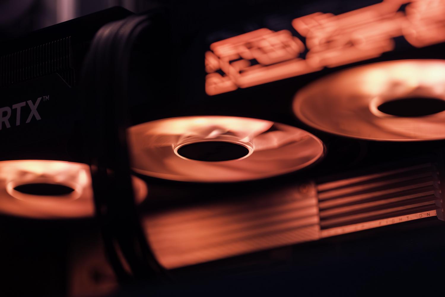Primer plano dinámico de los ventiladores de una tarjeta gráfica con iluminación roja, simbolizando el rendimiento y la potencia de los drivers Beta.