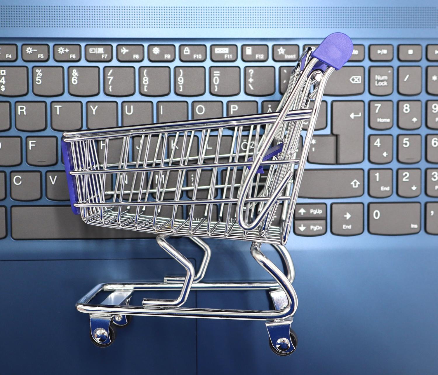 Miniatura de un carrito de compra sobre el teclado de un portátil, simbolizando la digitalización del comercio electrónico y los marketplaces.