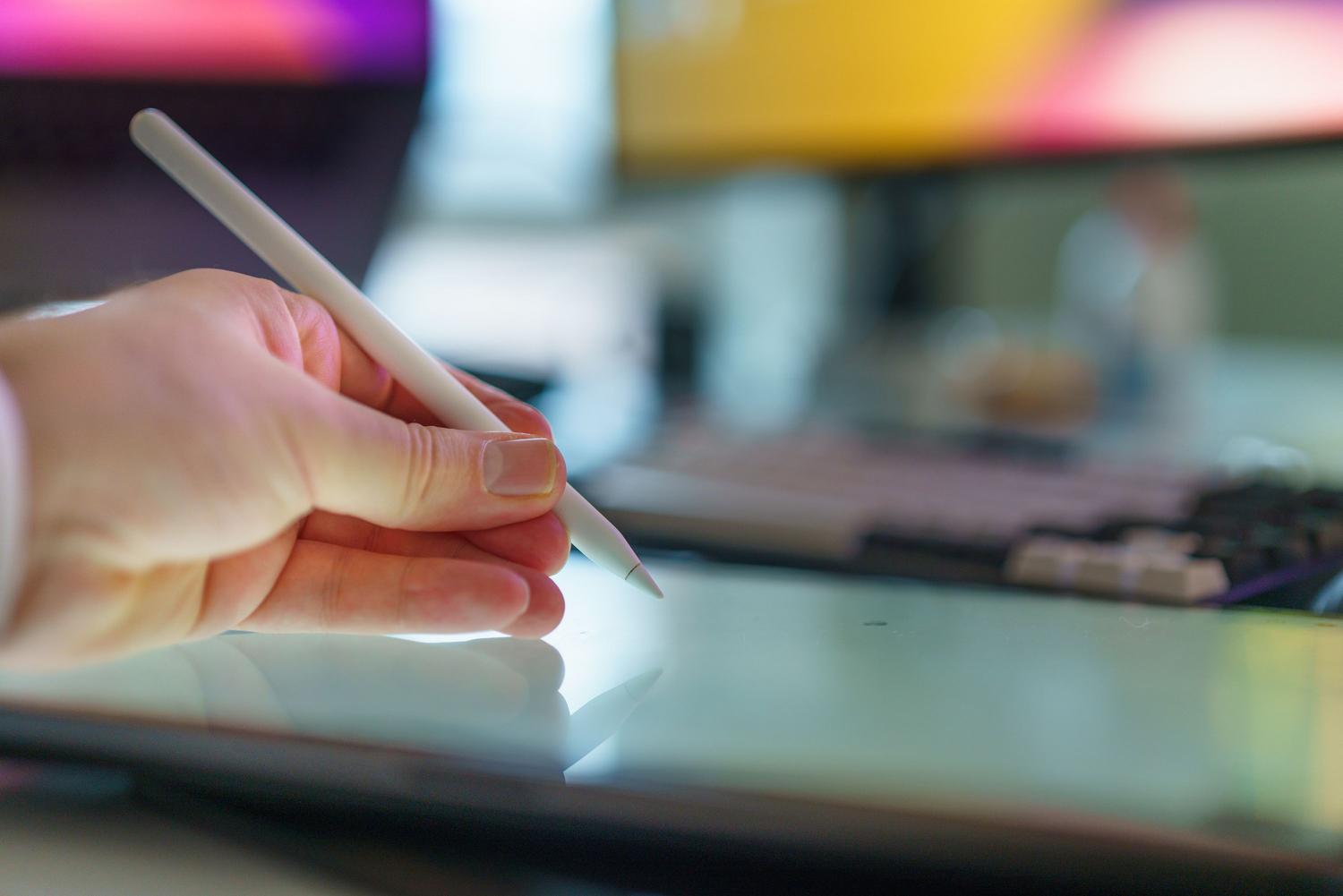 Mano utilizando un lápiz óptico digital sobre una tableta, representando la nueva interacción completa mediante stylus para superposiciones en KDE Plasma 6.8.