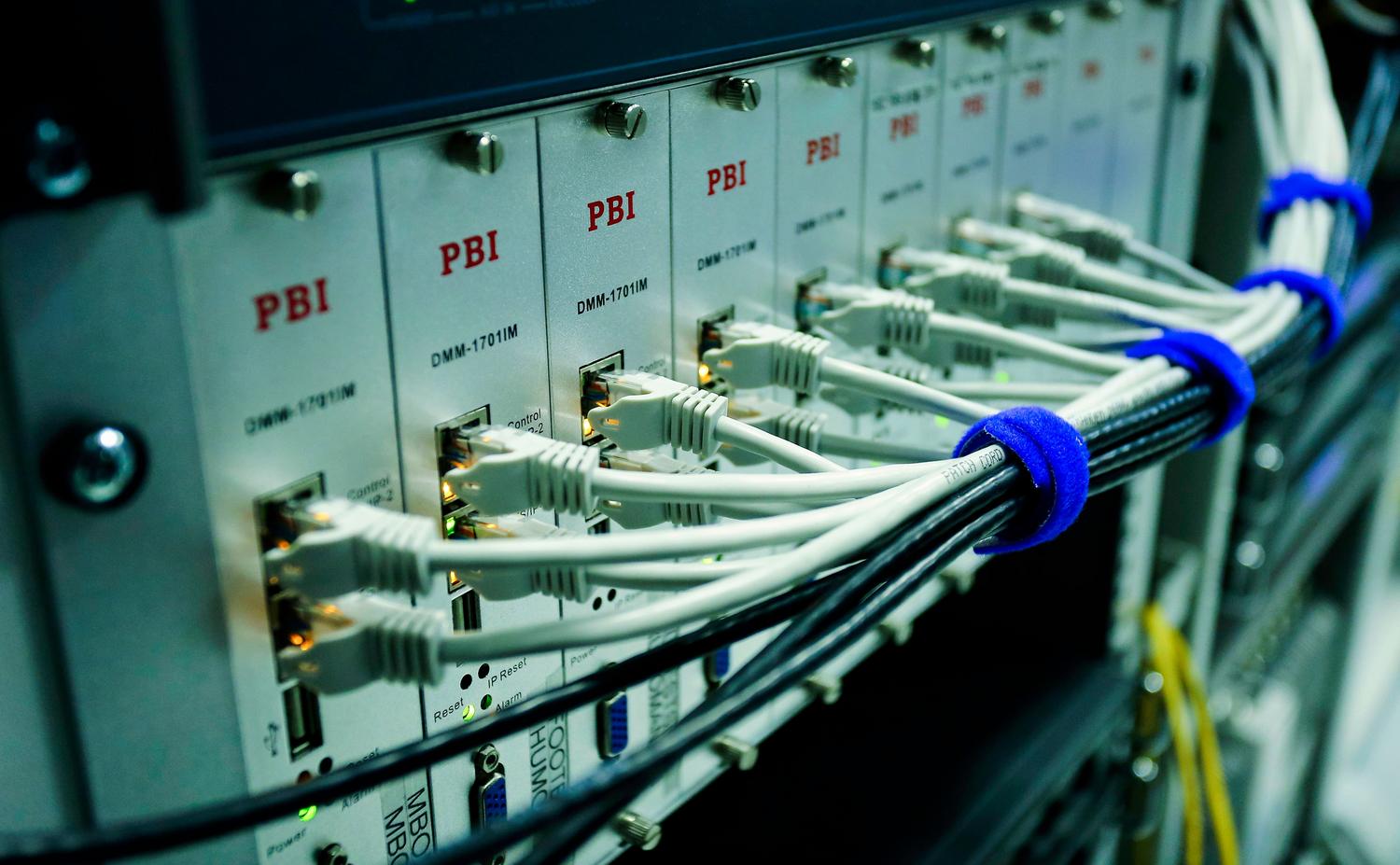 Cables Ethernet conectados a un switch de red, ilustrando la medición de conectividad y ancho de banda.