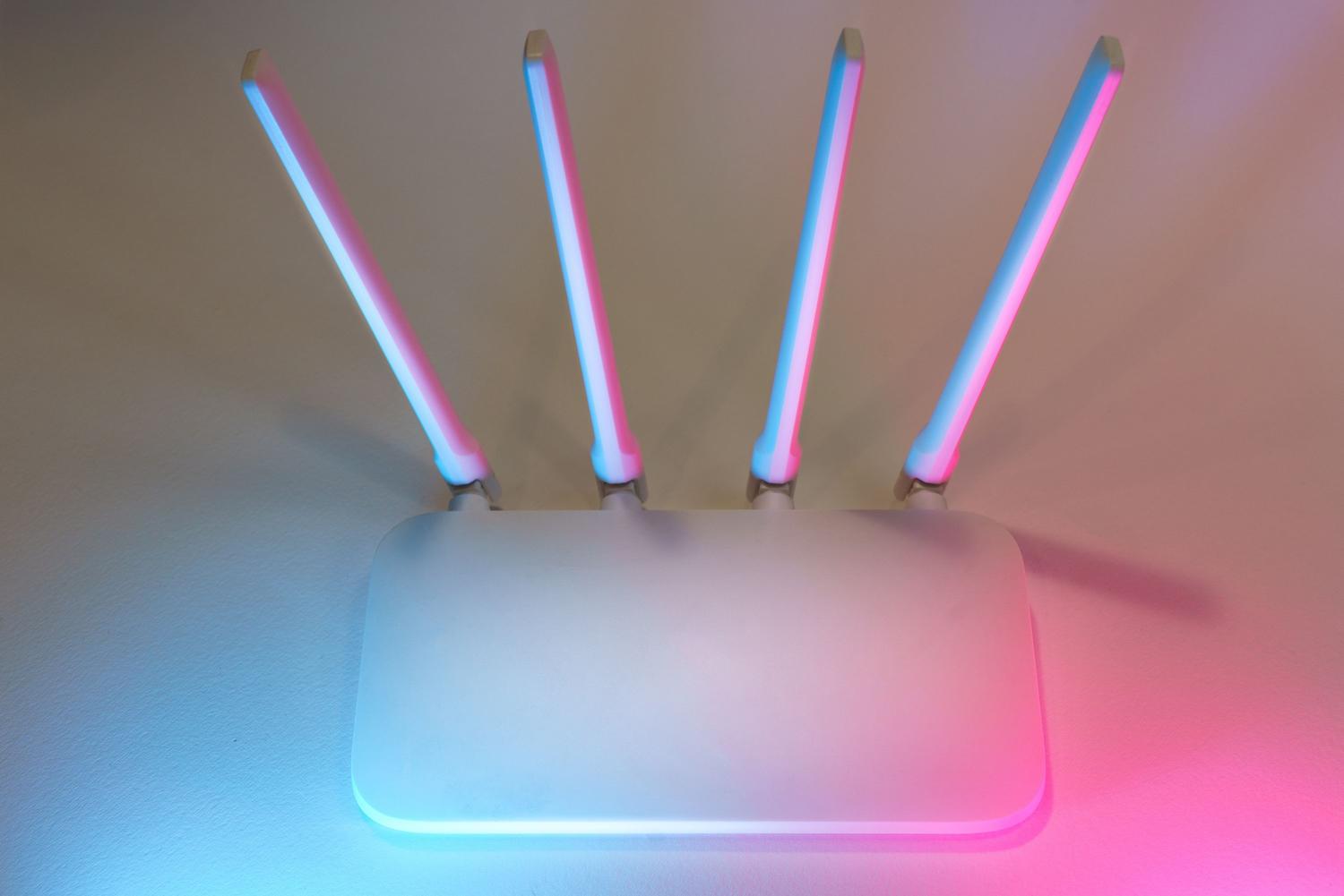 Router inalámbrico blanco con antenas y luces LED suaves, ideal para ilustrar la conectividad doméstica moderna.