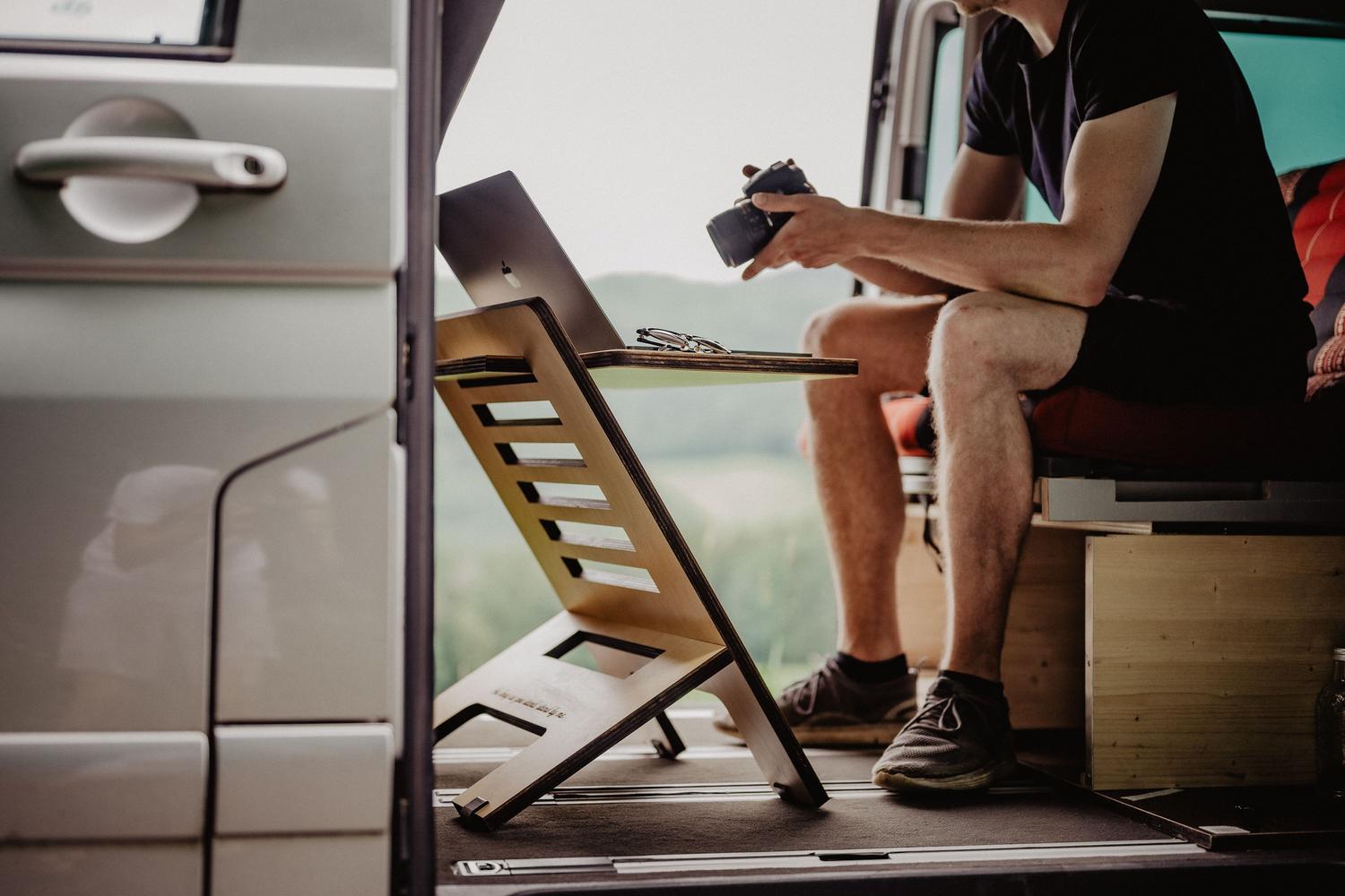 Hombre teletrabajando desde el interior de una furgoneta camperizada con un equipo portátil, mostrando la versatilidad del WiFi portátil.