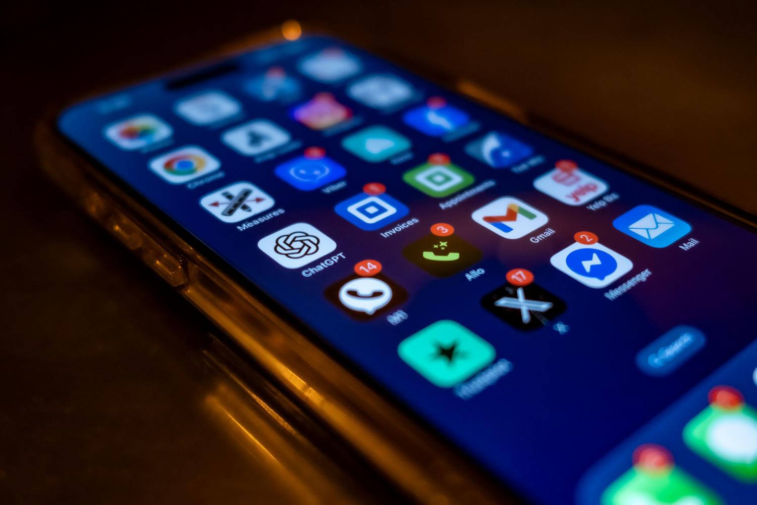Primer plano de pantalla de smartphone con múltiples insignias de notificaciones rojas, representando la saturación de avisos.