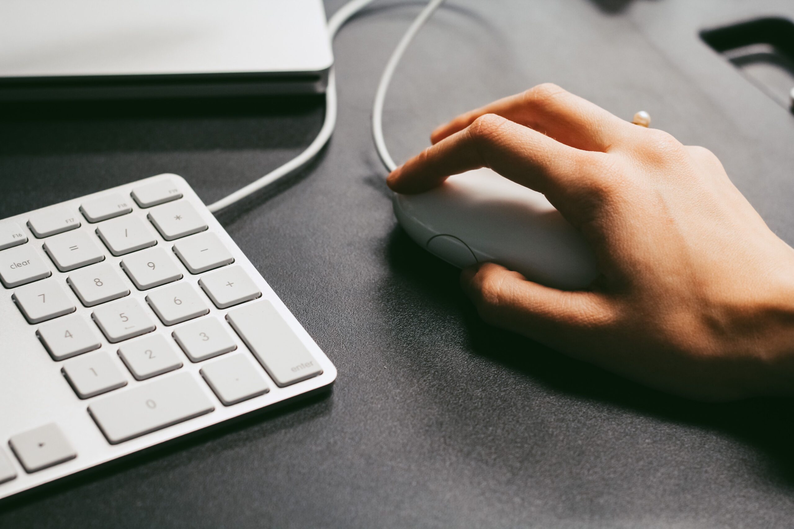 Persona utilizando un ratón ergonómico en un escritorio moderno y limpio