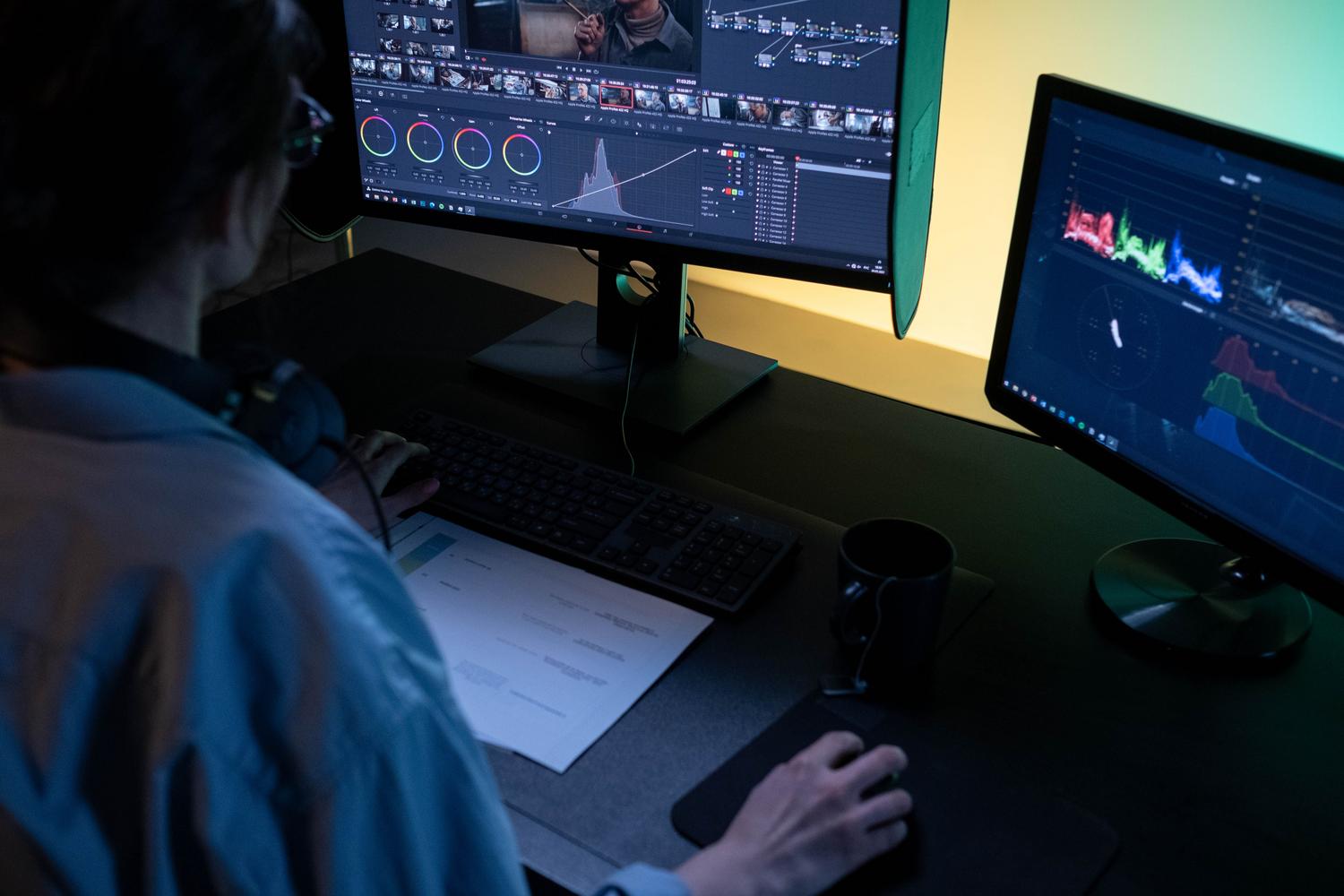 Creador de contenido editando video en un estudio con monitores IPS para asegurar la fidelidad del color.