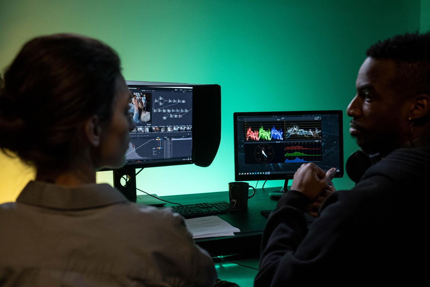 Dos profesionales colaborando frente a un monitor de alta gama, destacando los amplios ángulos de visión del panel IPS.