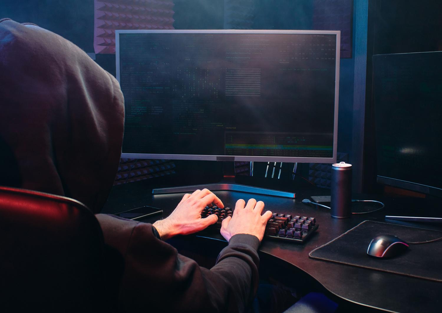 Persona utilizando un ordenador en un entorno oscuro, simbolizando la seguridad y el control del código abierto en Linux