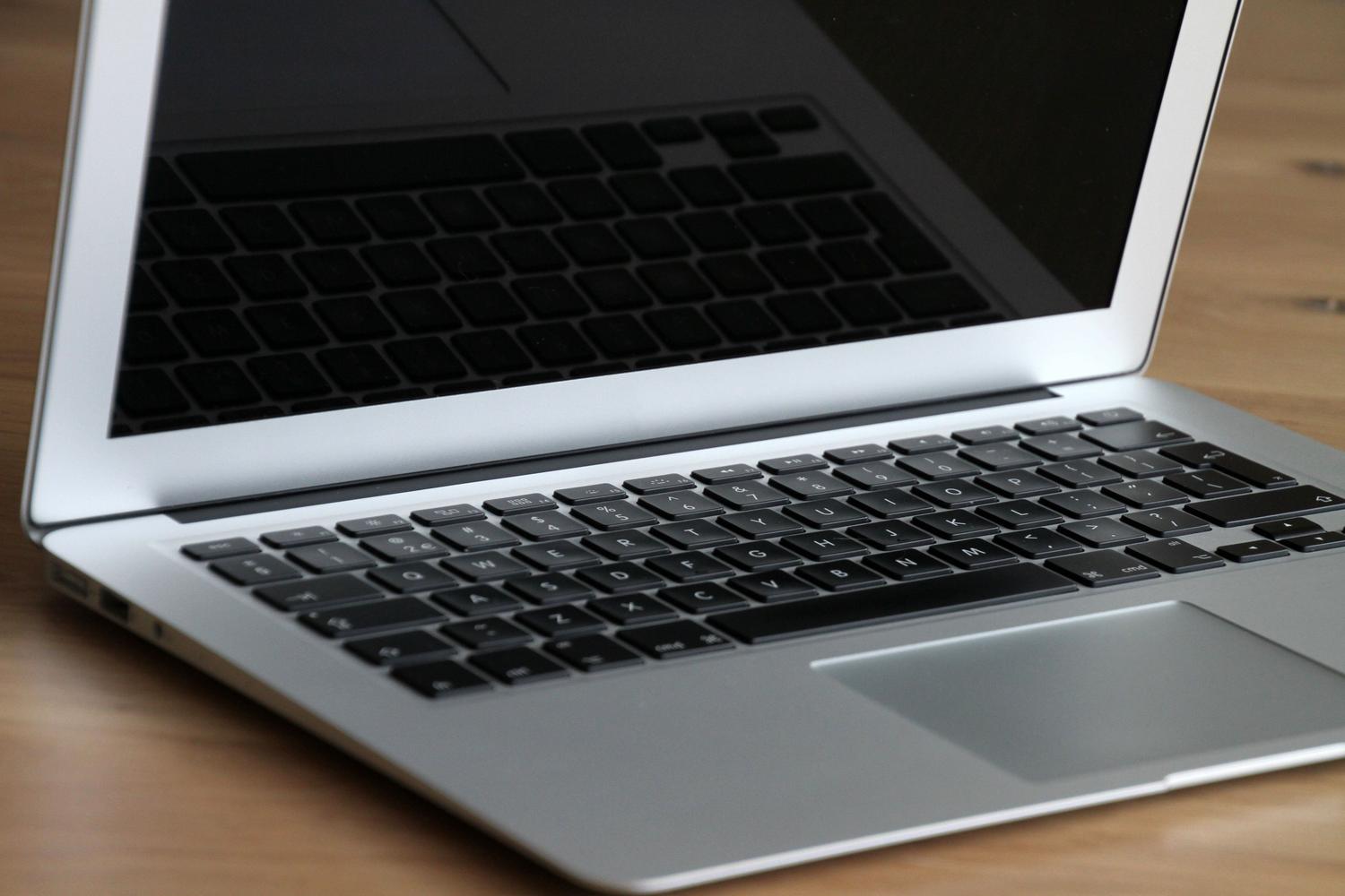 Ordenador portátil moderno sobre un escritorio de madera, ilustrando el hardware que puede ser revitalizado con Linux