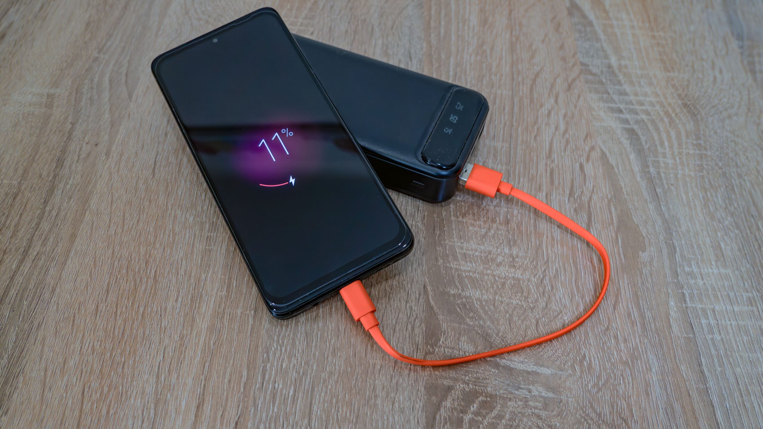 Smartphone cargándose con una batería externa, relacionando el contenido con el diagnóstico de la salud de la batería.