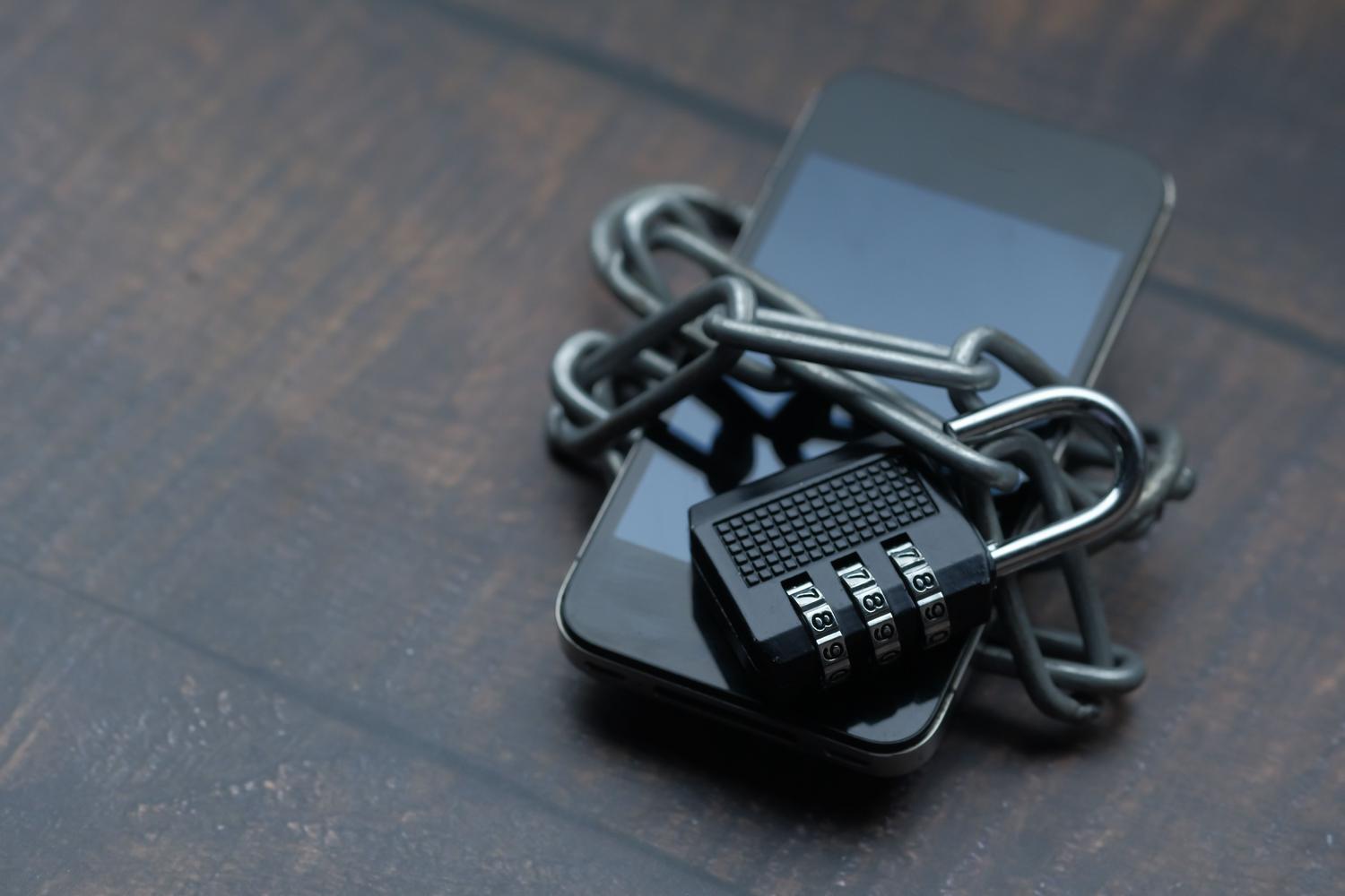 Smartphone envuelto en una cadena con un candado, metáfora de la seguridad robusta contra ciberataques