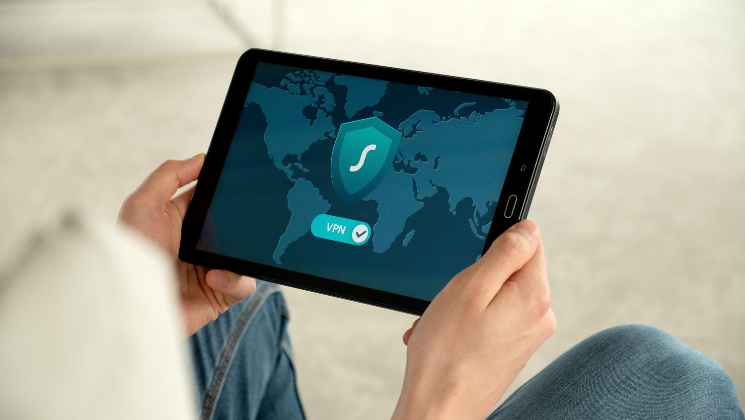 Persona utilizando una aplicación de VPN en una tablet para navegar de forma segura por internet