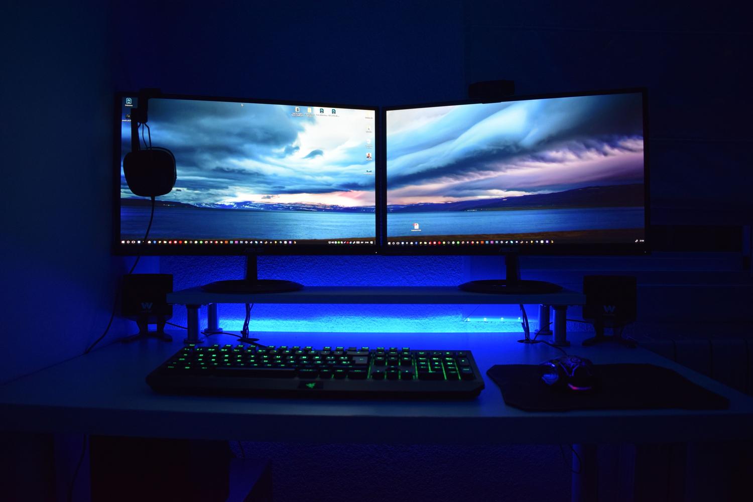 Setup de PC gaming avanzado con doble monitor e iluminación RGB, demostrando el alto consumo energético de los equipos de alto rendimiento.