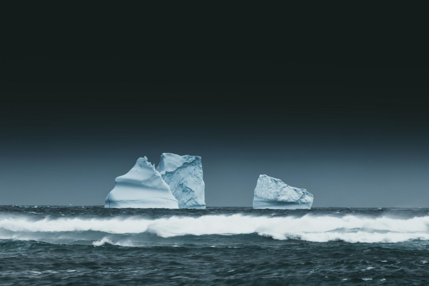 Iceberg flotando en el océano bajo un cielo oscuro, metáfora visual de la Surface Web, Deep Web y Dark Web.