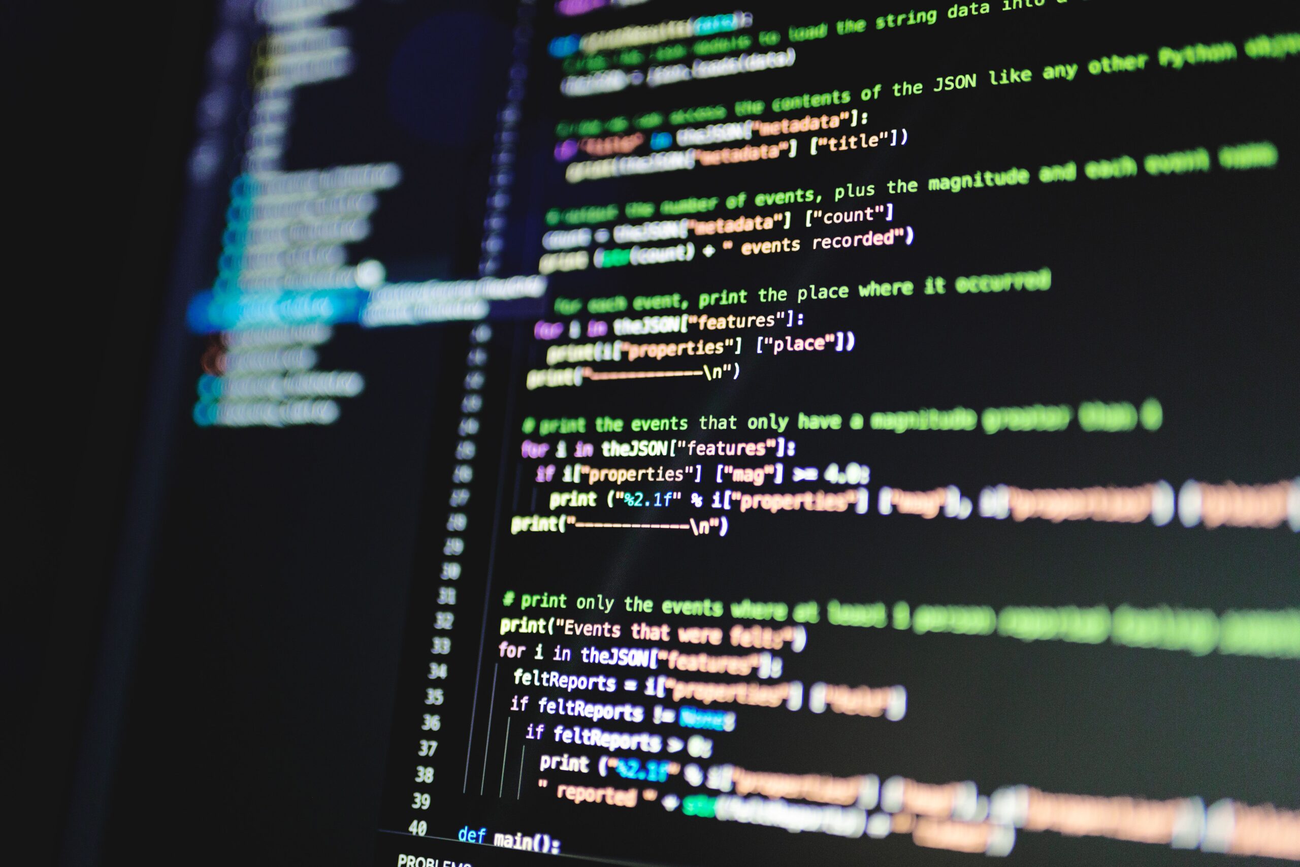 Primer plano de líneas de código de programación coloridas en un monitor con fondo oscuro, representando la estructura del software.