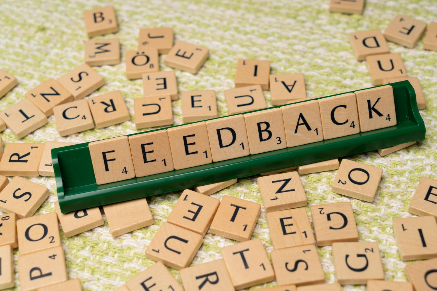 Letras de madera formando la palabra 'feedback' sobre un soporte, simbolizando la opinión de terceros en la reputación online.