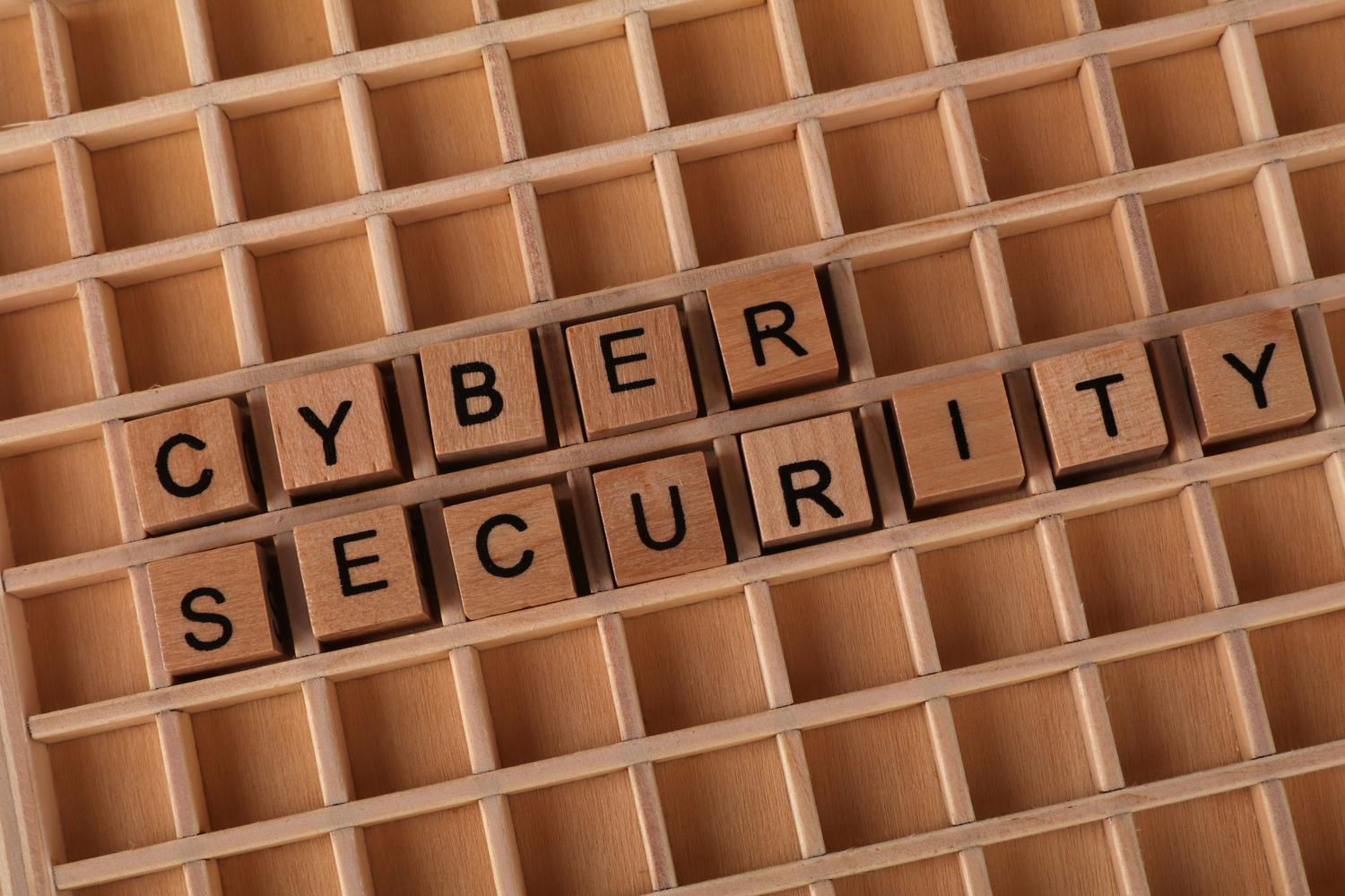 Bloques de madera formando las palabras 'Cyber Security' sobre un fondo de madera, representando los cimientos de la seguridad informática.