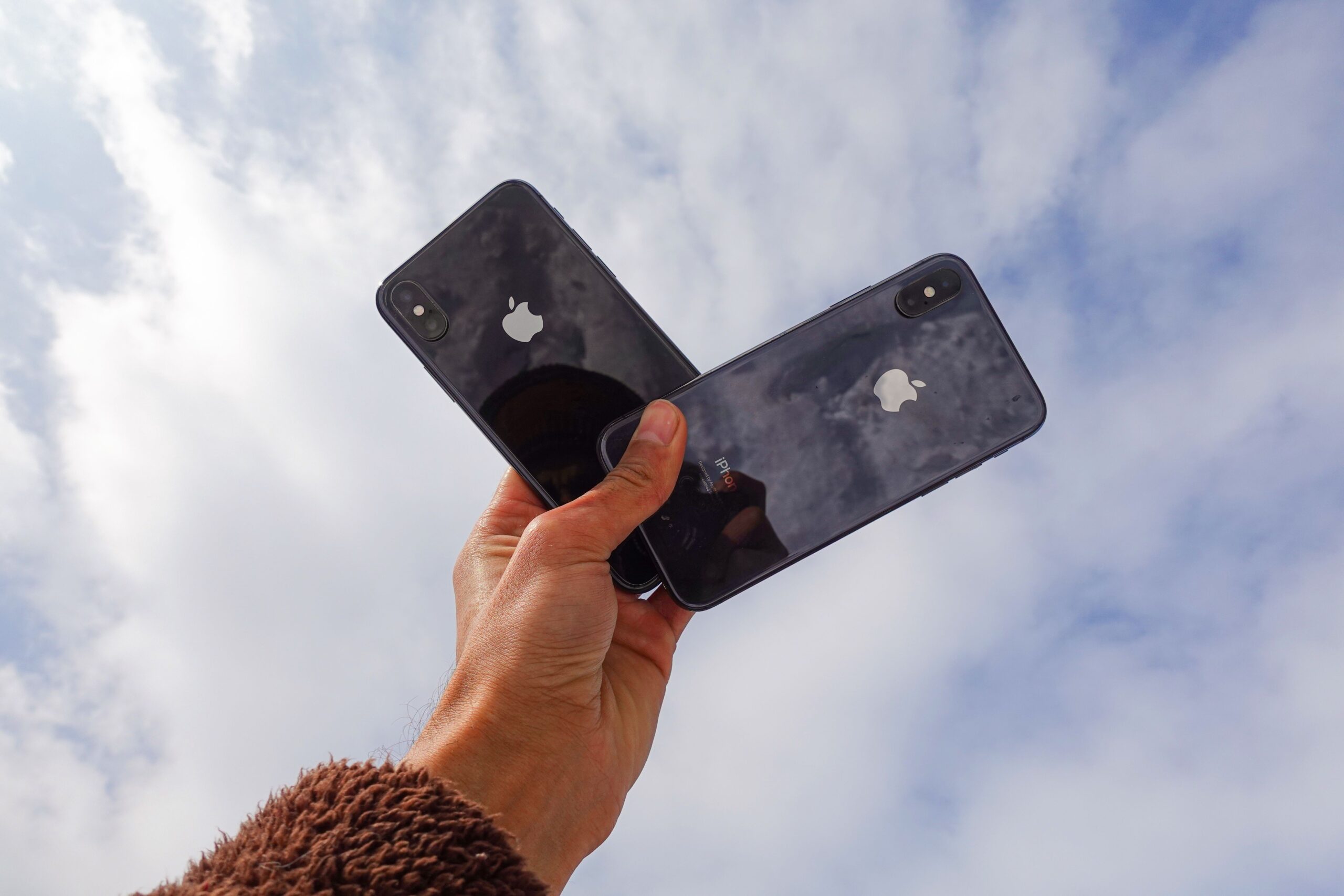 Mano sosteniendo dos smartphones modernos, ideal para representar la compatibilidad entre modelos.