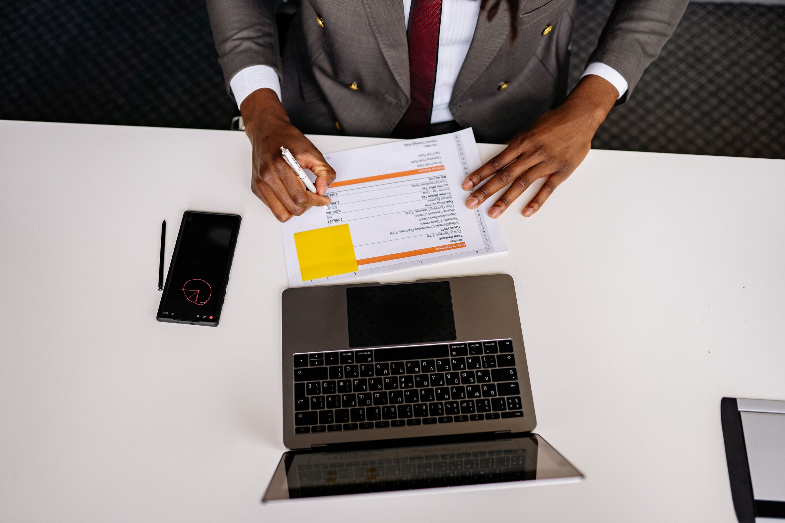 Profesional analizando documentos impresos y digitales en un entorno de trabajo limpio