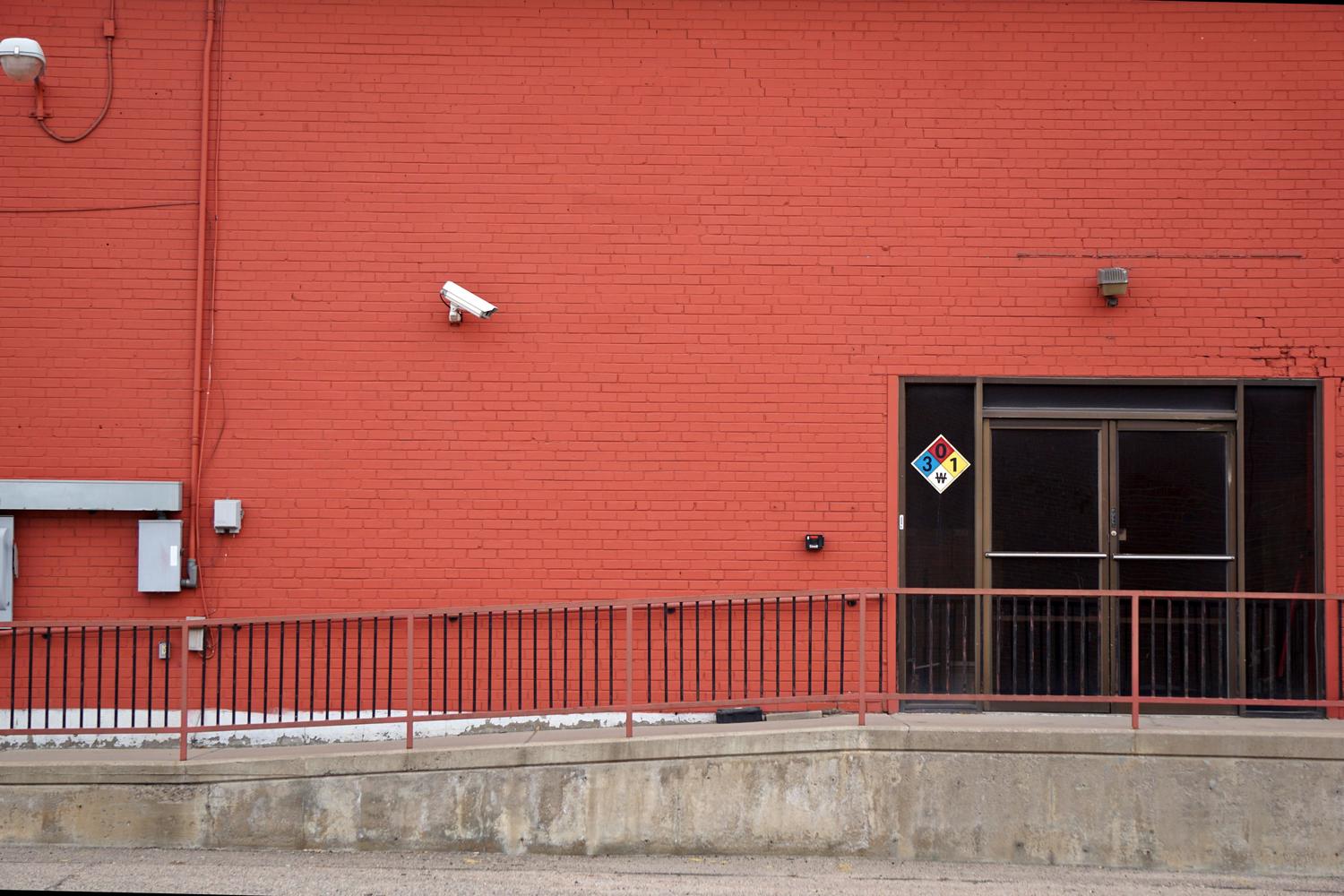 Cámara de vigilancia instalada en la fachada de un edificio industrial para la protección de activos.