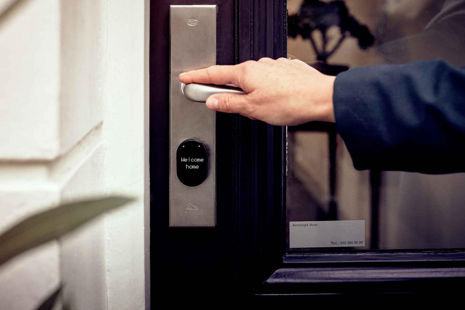 Cerradura inteligente con panel de acceso digital en la puerta de una vivienda moderna.