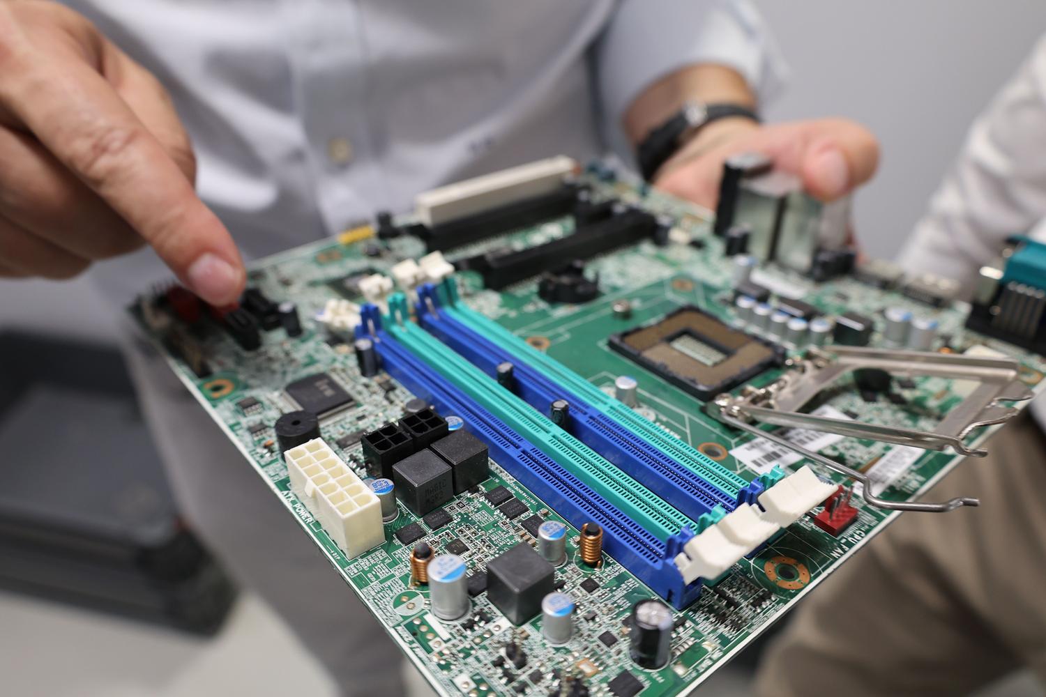 Técnico revisando una placa base de ordenador, representando el proceso de configuración del hardware.