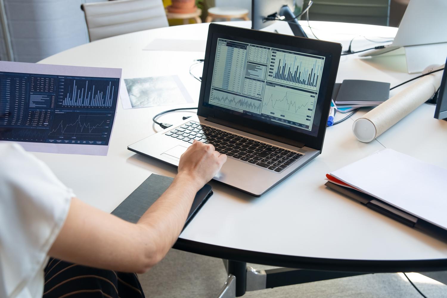 Professional analyzing business data on a laptop, depicting the process of structuring scrapped lead information.