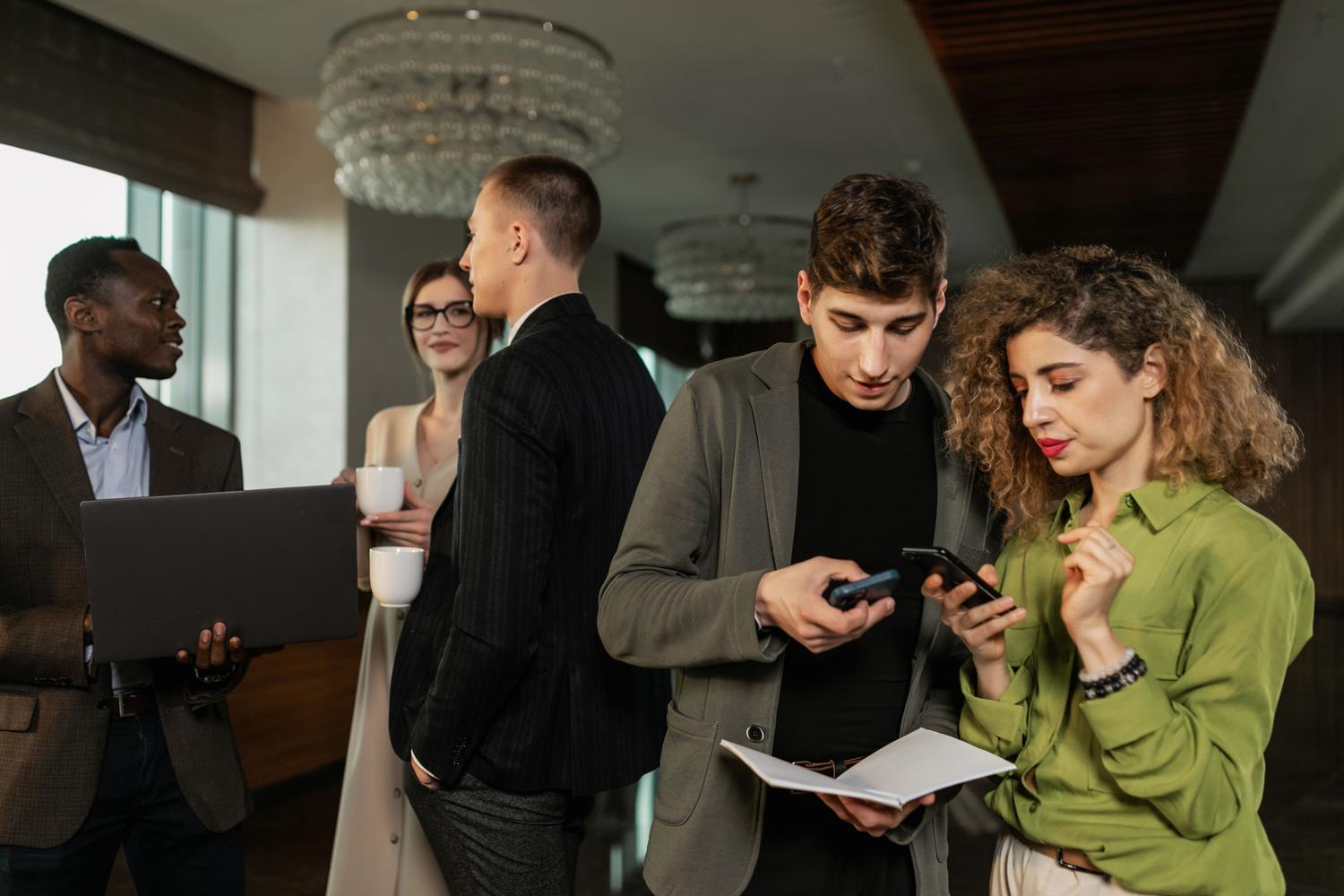 Diverse group of B2B professionals networking with digital devices, symbolizing the target of lead generation strategies.