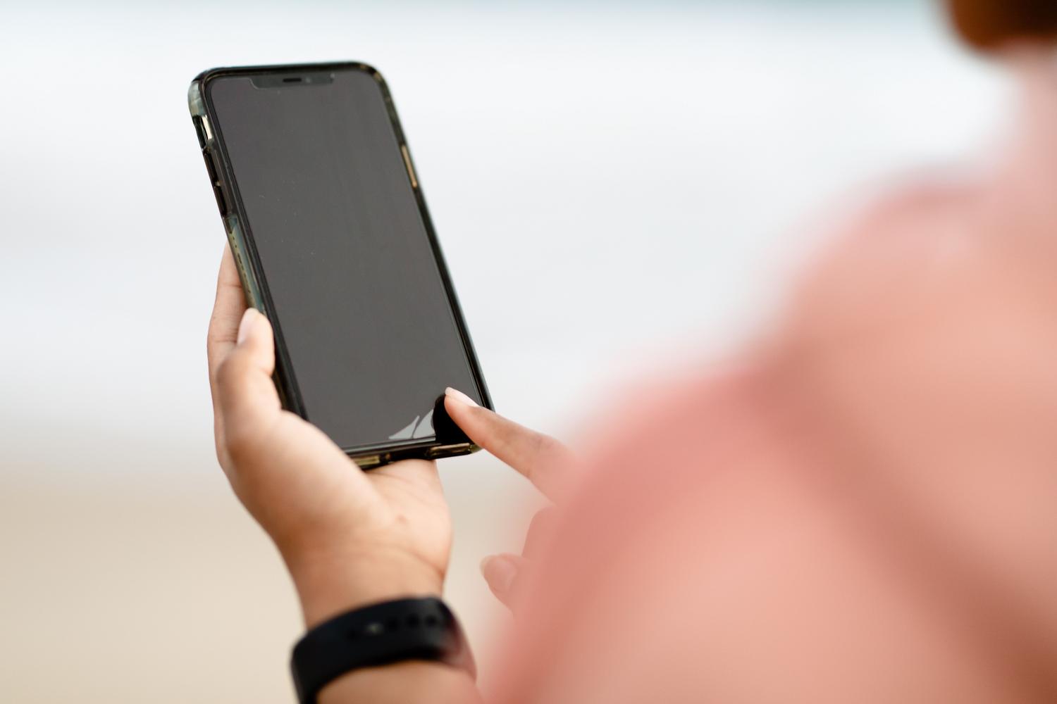 Una mano interactuando con la pantalla de un smartphone al aire libre, ilustrando la configuración de la copia de seguridad automática en Android.
