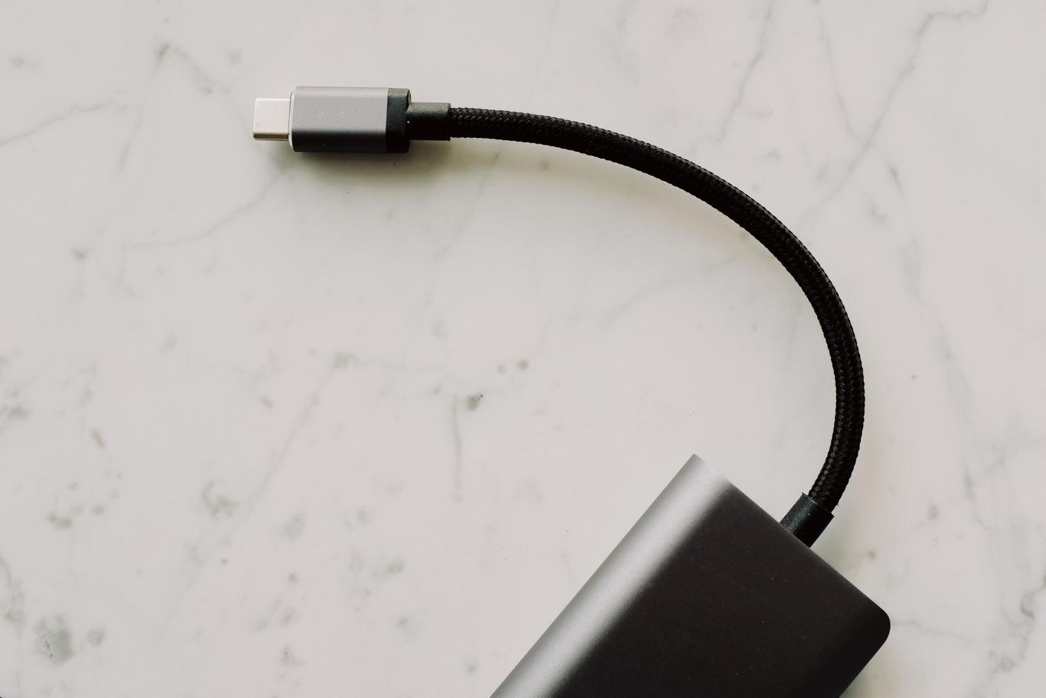 Primer plano de un cable USB-C sobre una superficie de mármol, ideal para ilustrar la transferencia de datos mediante cable.