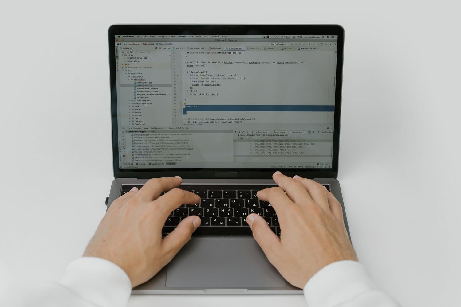 Close-up of hands typing on a laptop keyboard, illustrating the process of entering PowerShell commands