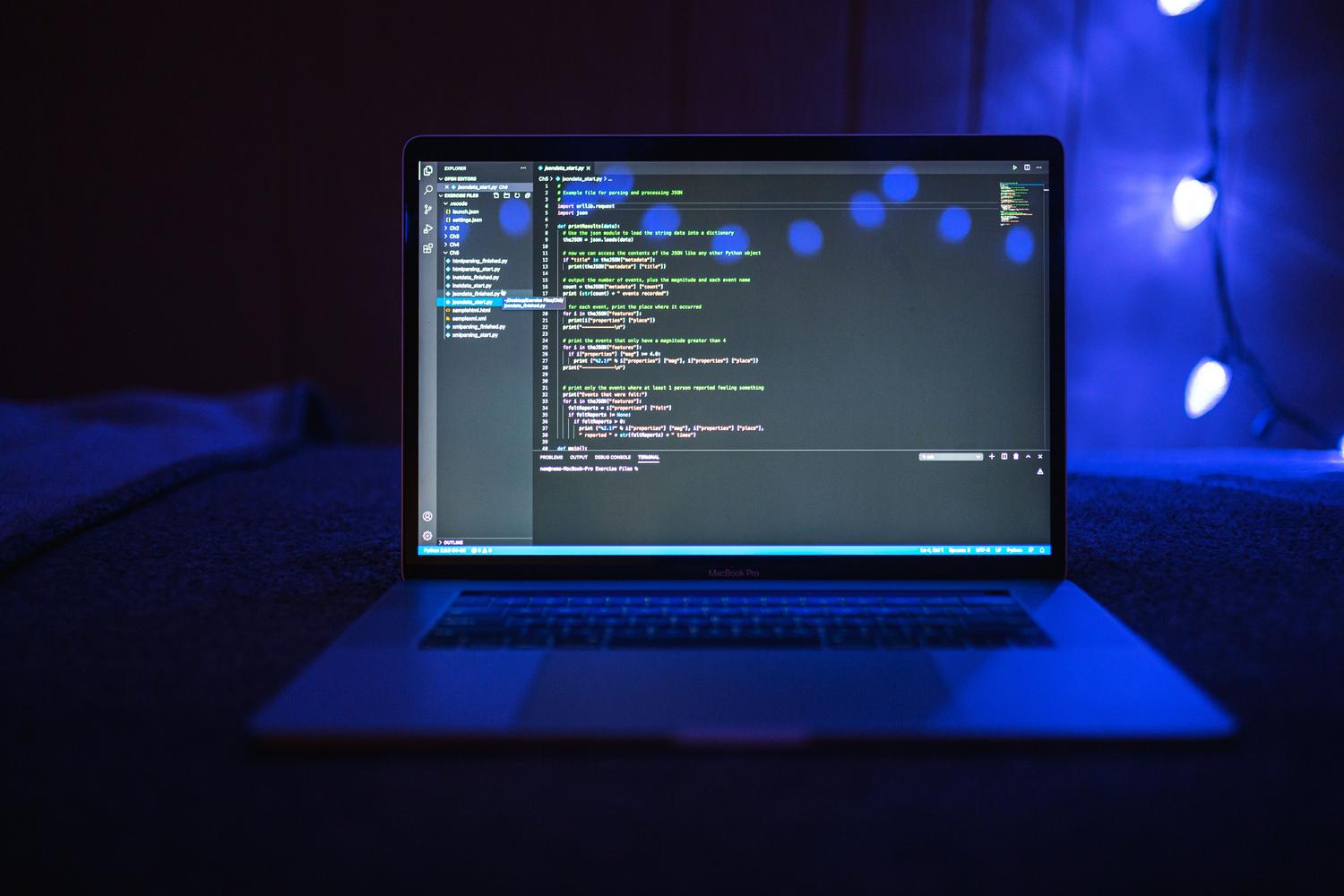 Detailed view of colorful code on a screen with blue ambient lighting, representing advanced scripting and automation