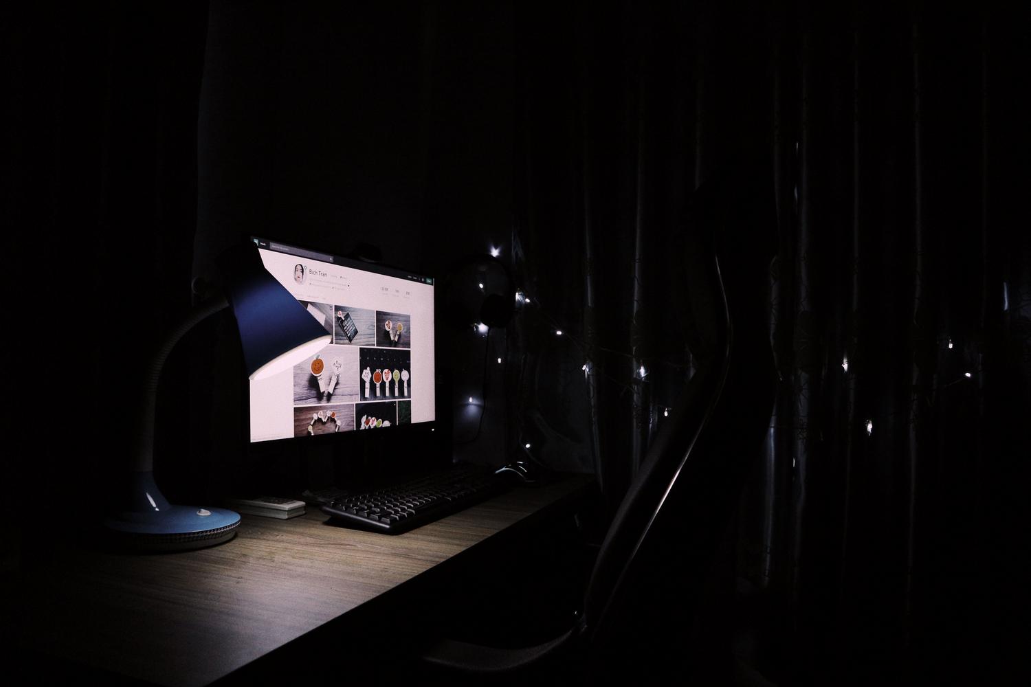 Escritorio de oficina en casa con iluminación tenue, ilustrando la importancia de la luz nocturna y el cuidado visual.