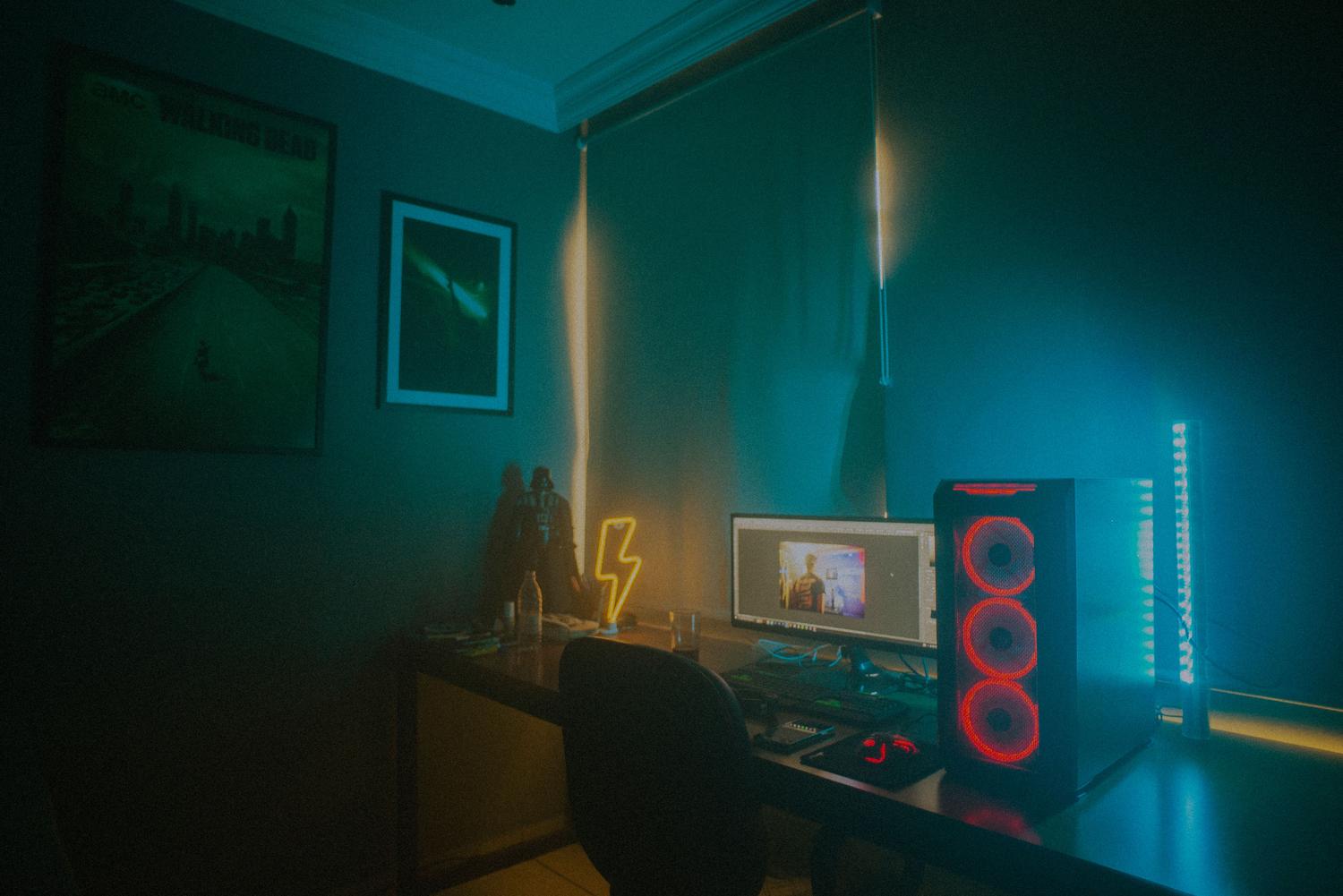 Escritorio gaming minimalista con PC iluminado y luces de neón ambientales en la habitación.