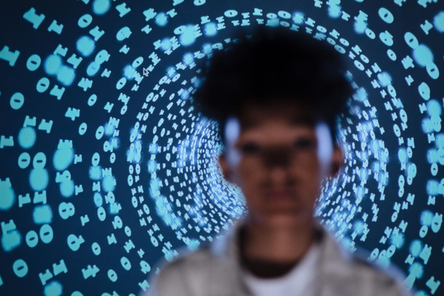 Persona frente a una proyección de códigos digitales, representando el rastro de datos en internet