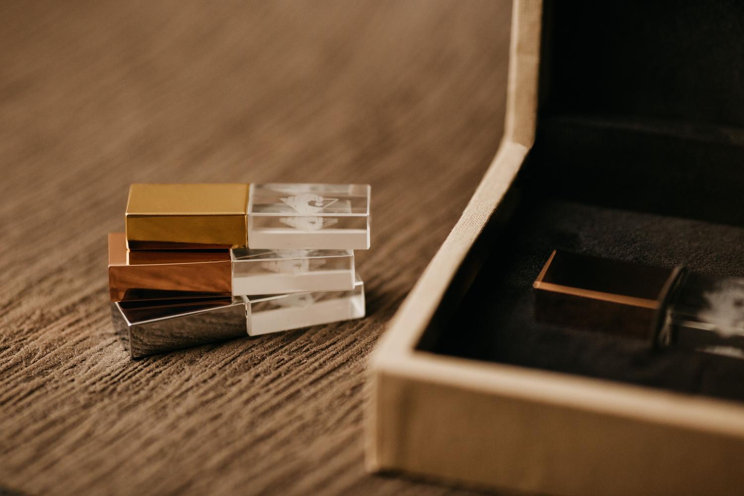 Varios pendrives USB de diferentes colores sobre una superficie de madera, representando la importancia de tener copias de seguridad.