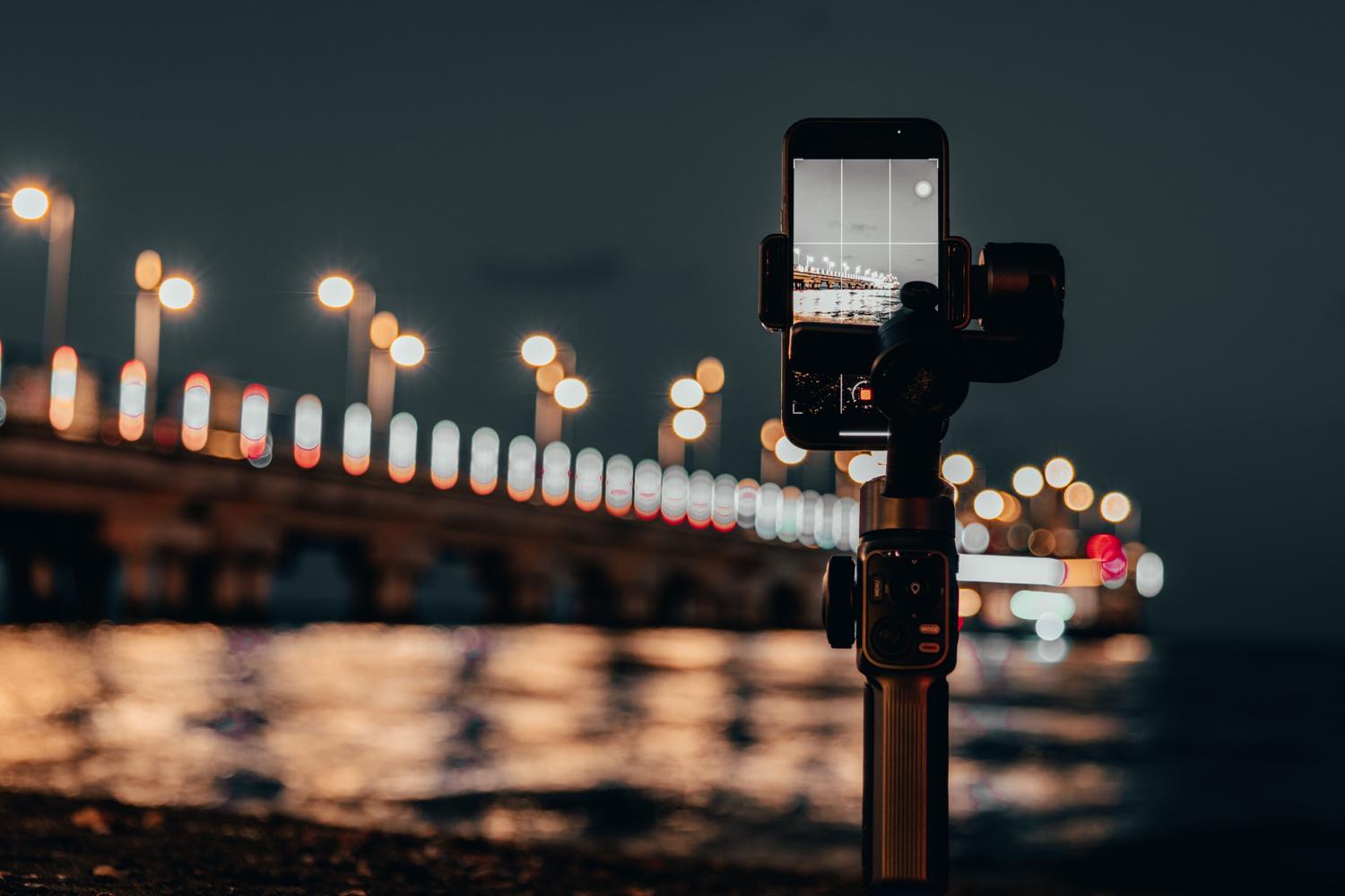 Smartphone montado en un estabilizador gimbal durante la noche para lograr una exposición prolongada sin movimiento.