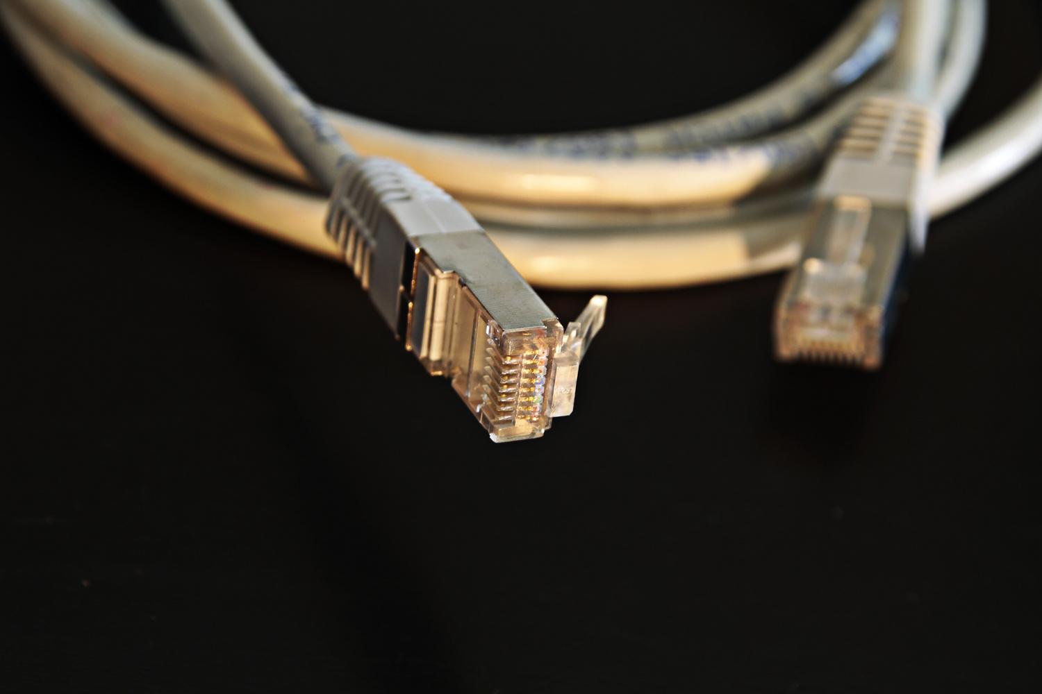 Primer plano detallado de un conector de cable Ethernet, destacando la estabilidad de una conexión por cable frente al Wi-Fi.