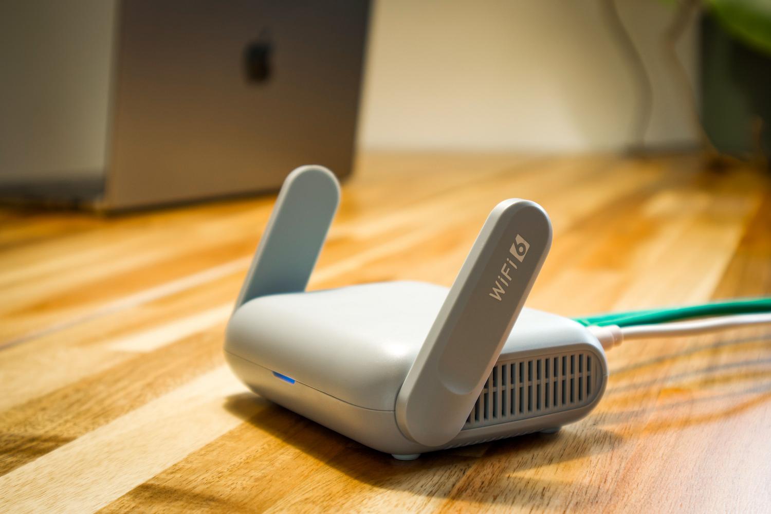 Router inalámbrico moderno WiFi 6 sobre un escritorio, ideal para ilustrar la optimización del hardware de red.