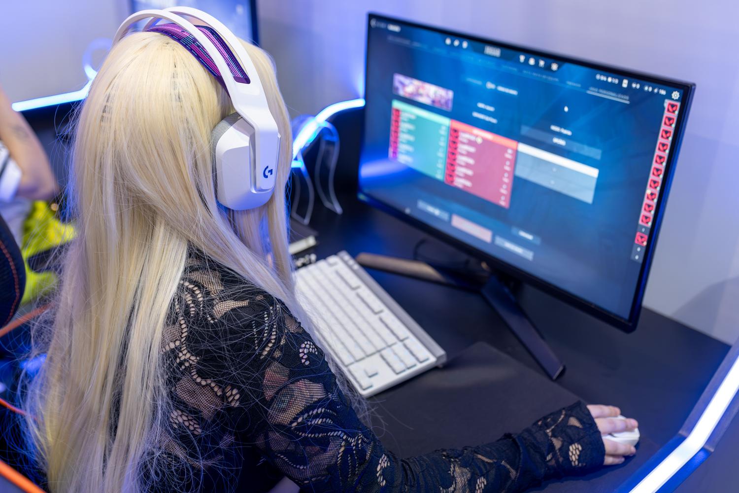 Jugadora utilizando un equipo de PC de alta gama con auriculares